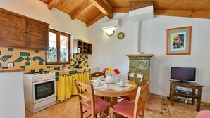 Una cocina acogedora con armarios de madera, estufa y comedor con sillas y mesa.
