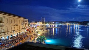 A waterfront promenade with cafes and restaurants, a marina with boats, and a large building with arched windows. - Charming Bungalow with a Terrace - Pet Friendly (Porec)