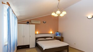 A bedroom with a bed, a wardrobe, a television, and a ceiling light fixture. - Charming Bungalow with a Terrace - Pet Friendly (Porec)