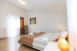 A hotel room with a bed, a chair, a painting, and a vase. - Ultimate Relaxation at Our Beautiful Villa: Private Pool, Jacuzzi, and BBQ Near Poreč (Stanici Kod Nove Vasi)