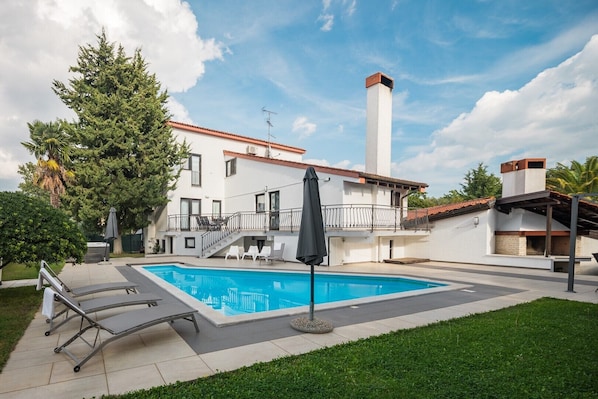 A modern building with a swimming pool, outdoor seating, and a large tree. - Ultimate Relaxation at Our Beautiful Villa: Private Pool, Jacuzzi, and BBQ Near Poreč (Stanici Kod Nove Vasi)