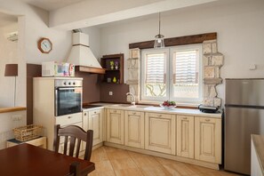 Une cuisine équipée d’une cuisinière, d’un four, d’un évier et d’un réfrigérateur.