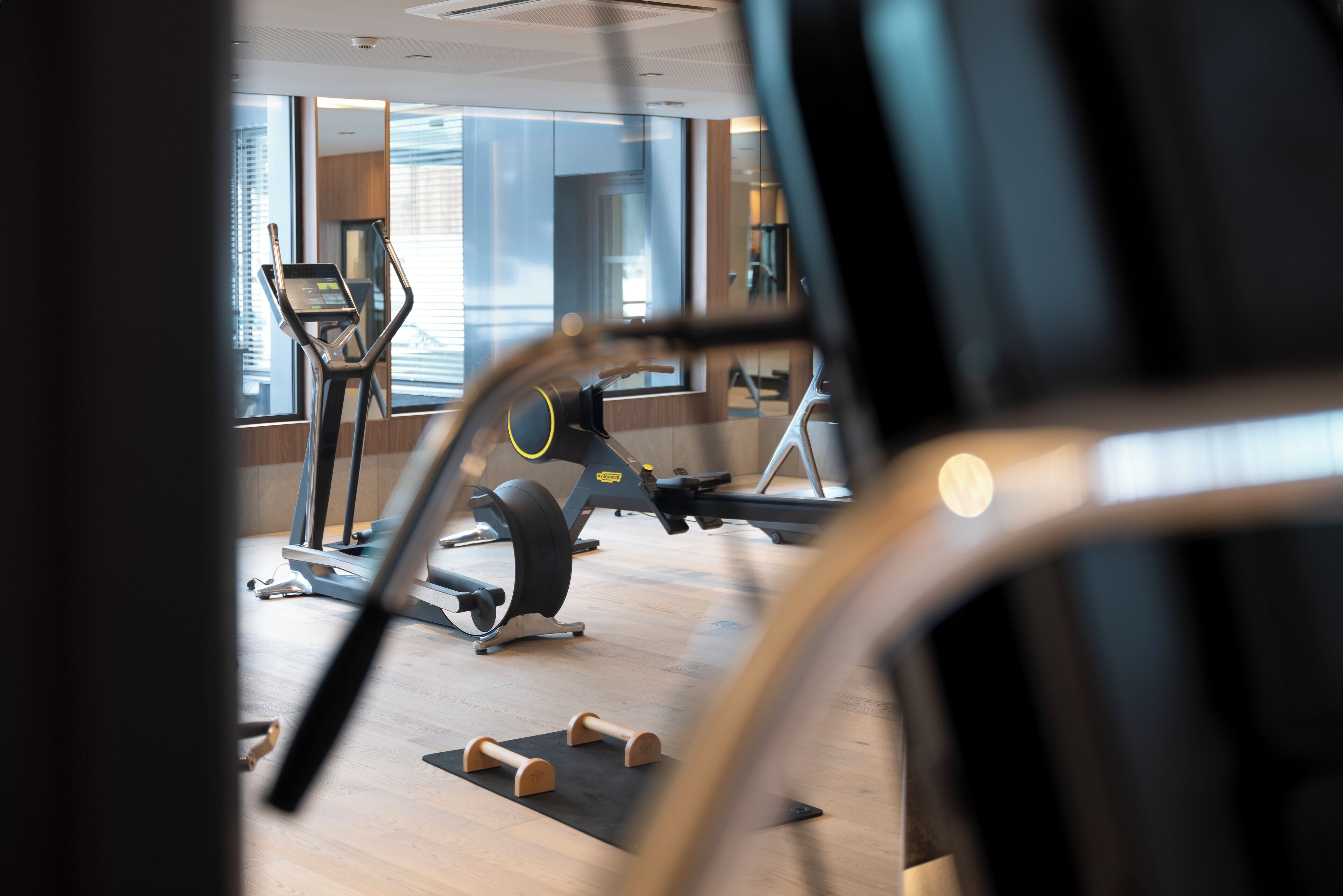 Une salle de sport équipée de matériel d’exercice, dotée de grandes fenêtres et d’un aménagement intérieur moderne.