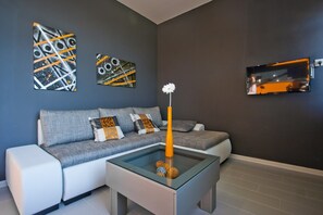 Relax in this stylish living room with a comfortable sofa, coffee table, and large flat-screen TV.