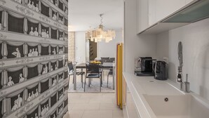 Una cocina moderna con lavavajillas incorporado, cafetera y fregadero.