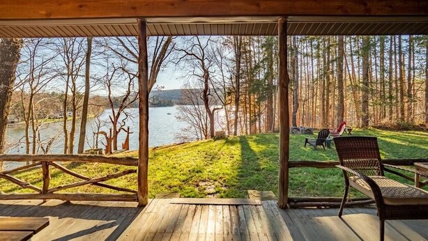 A wooden deck with a view of a lake and forest. - Lakefront, family friendly home -Baseball campers! (Oneonta)