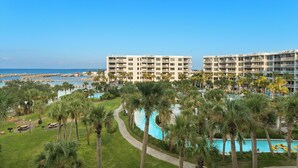 A hotel with multiple floors, a swimming pool, and a view of the ocean. - Destin West Heron 505 ~ 3BR/2.5BA ~ Bay Views ~ Overlooking the Lazy River (Fort Walton Beach)