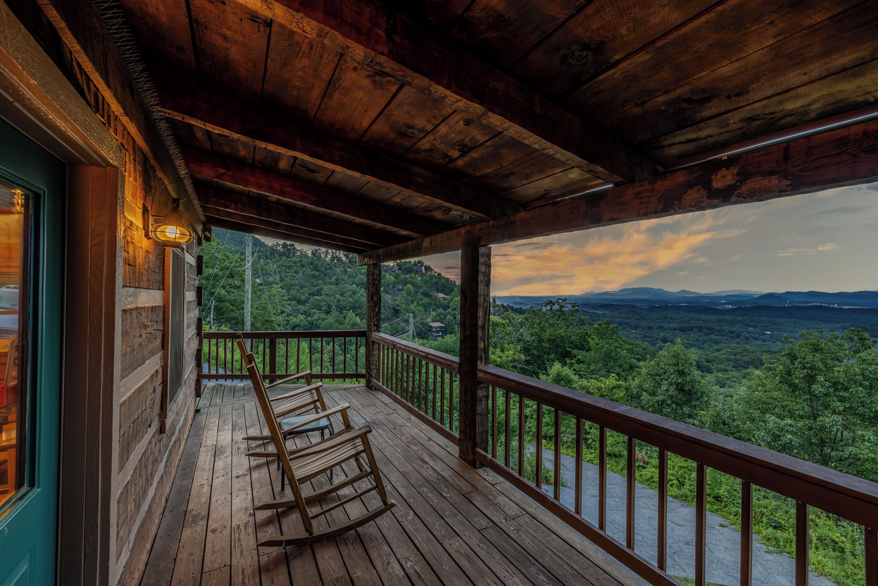 A wooden porch with a view of a mountainous landscape.