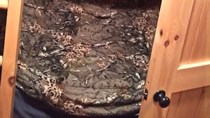 Una litera de madera con un colchón cubierto de plástico protector.