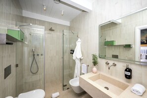 Ein modernes Badezimmer mit einer Duschkabine, einem großen Waschbecken und einem Spiegel.