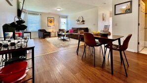 Un vaste espace de vie comprenant un canapé, une table basse et une table à manger avec des chaises.