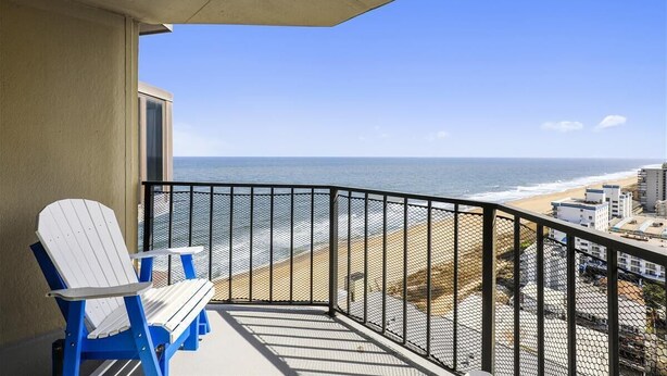 Ein Balkon mit Blick auf Strand und Meer.