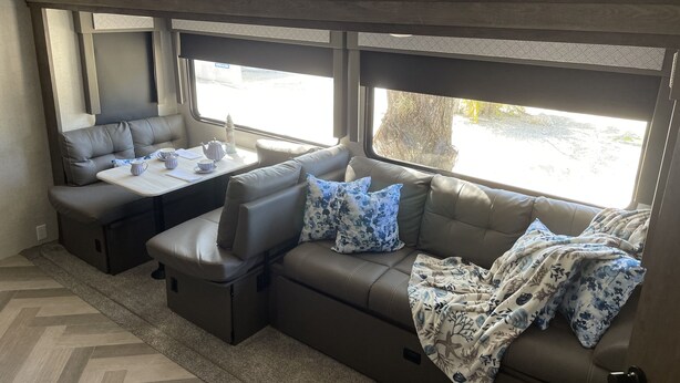 A cozy RV interior with a sofa, a table with tea set, and a 'Welcome to the Beach' sign. - The place to go when you want to get away! (Key Largo)