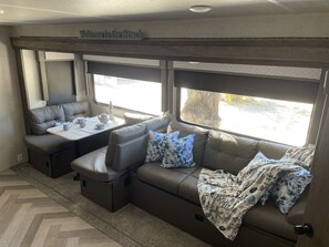 A cozy RV interior with a sofa, a table with tea set, and a 'Welcome to the Beach' sign. - The place to go when you want to get away! (Key Largo)