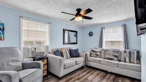 A living room with a grey sofa set, a grey armchair, and a ceiling fan. - 3 BEDROOM BEACH HOUSE WITH GOLF CART! (Myrtle Beach)