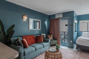 Ein modernes Wohnzimmer mit einer Couch, einem kleinen runden Tisch und einem Bett.