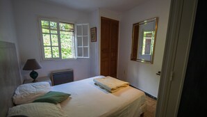 A bedroom with a bed, a window, a door, and a mirror. - 6-person gîte in the large building on the Garidels estate (Gravières)