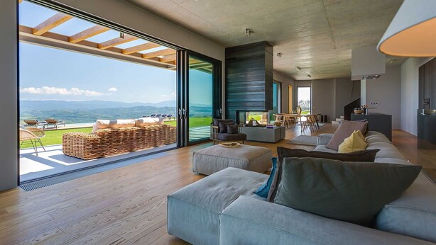 A spacious living area with a large sliding glass door leading to a balcony overlooking a scenic landscape. - Villa Grand Horizon with Pool (Pazin)