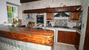 Una cocina con encimera de madera, salpicadero de azulejos y armarios de madera.