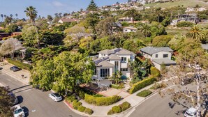 A residential area with modern houses, a street, and surrounding greenery. - Large Home with Ocean Views & Hot Tub! (Santa Barbara)