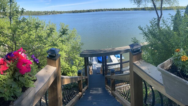 A wooden bridge leading to a gazebo overlooking a lake. - Pet Friendly Huge Lake Front Home with Stunning Views (Round Lake Park)