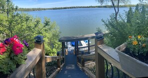 Eine Holzbrücke führt zu einem Pavillon mit Blick auf einen See.