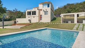 Un edificio moderno de dos pisos con una piscina al frente.