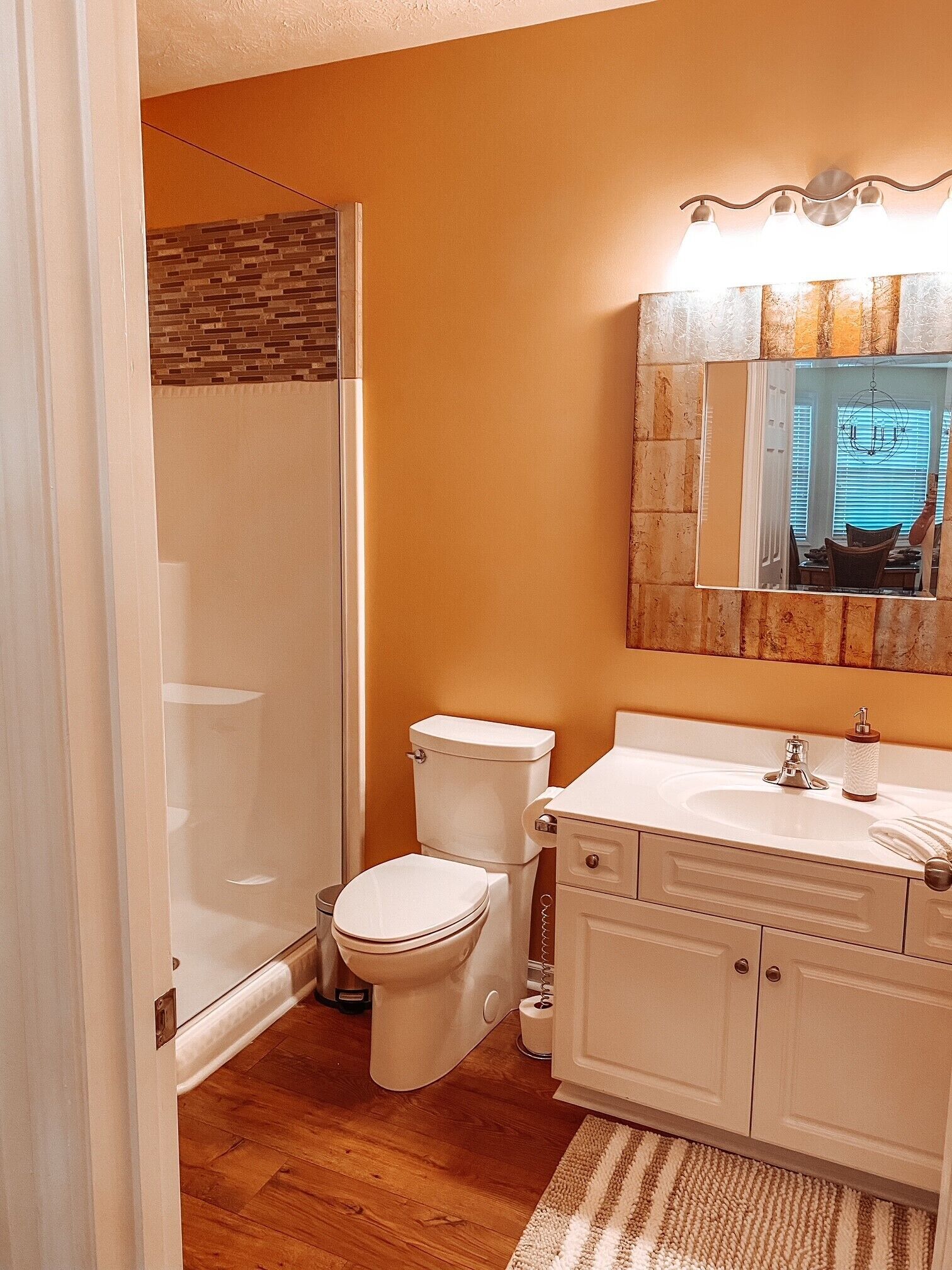 A bathroom with a shower, toilet, and sink.