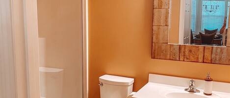 A bathroom with a shower, toilet, and sink.