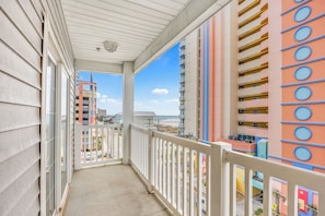 A balcony with a view of a beach and colorful buildings.