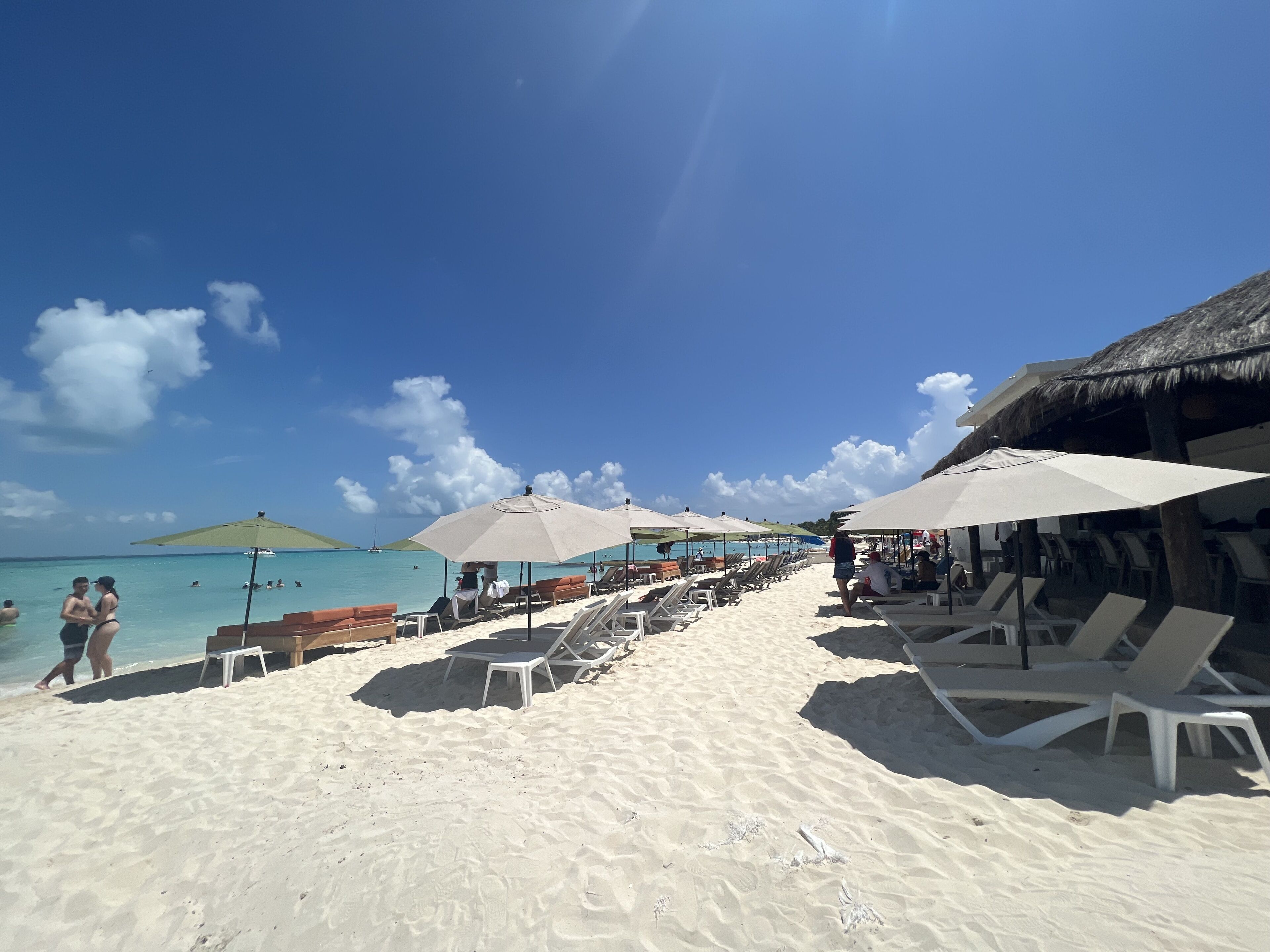 On the beach, white sand, beach umbrellas, 2 beach bars