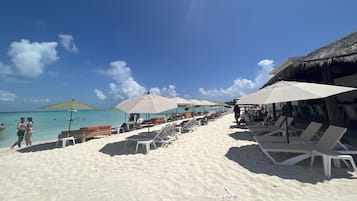 On the beach, white sand, beach umbrellas, 2 beach bars