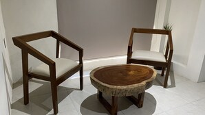 Dos sillas de madera con asientos acolchados y una mesa redonda de madera con borde natural.
