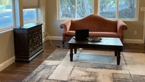 Uma sala de estar com um sofá marrom, uma mesa de centro e um armário de madeira escura.