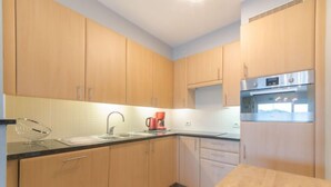 A kitchen with wooden cabinets, a stainless steel oven, and a coffee maker.