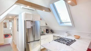 A modern kitchen with a stainless steel refrigerator, a gas stove, and a skylight. - 1 Min. Walk to Water/Town Deck and A/C! (Provincetown)