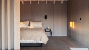 A modern bedroom with a bed, bedside table, and a wardrobe. - Radar by Bloom Stays - sleeps 4 on nature reserve (Dungeness)