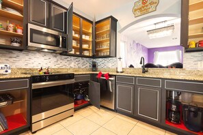 A modern kitchen with built-in appliances, a microwave, oven, and a coffee maker.