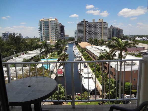 A high-rise building with a view of a marina and a pool.