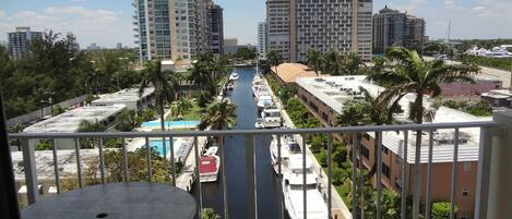 A high-rise building with a view of a marina and a pool.