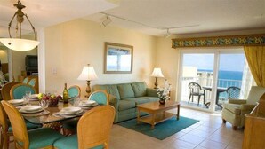 A living room with a dining table set for four, a sofa, and a balcony with a view. - 1 BR Condo 1406L - 2 blocks off beach with great Ocean and Intercoastal Views. (Fort Lauderdale)