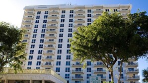 A multi-story hotel with balconies, a sign indicating it is a hotel, and trees in the foreground. - 1 BR Condo 1406L - 2 blocks off beach with great Ocean and Intercoastal Views. (Fort Lauderdale)