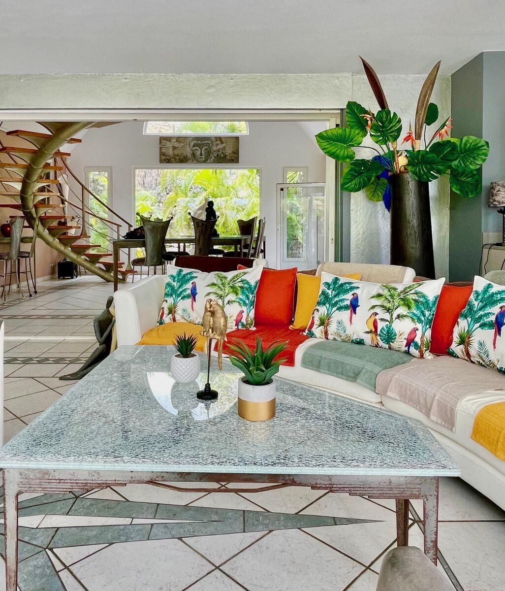 A modern living room with a sofa, coffee table, and decorative plants.