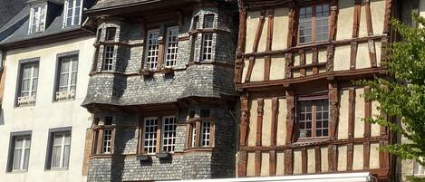 A traditional half-timbered building with a shop named 'LE BARN'S' on the ground floor.