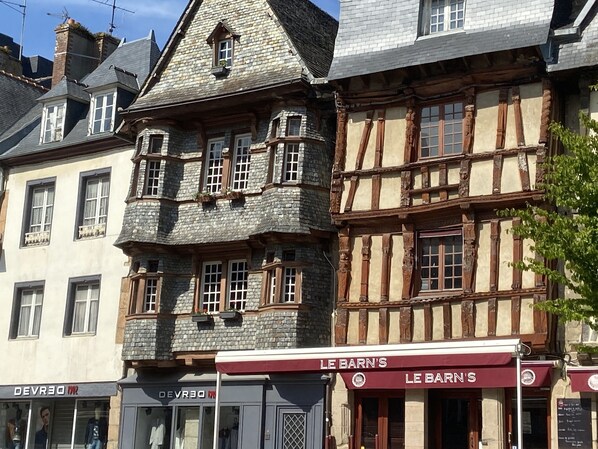 A traditional half-timbered building with a shop named 'LE BARN'S' on the ground floor.