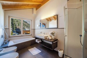 Bathtub, hair dryer, bathrobes, towels