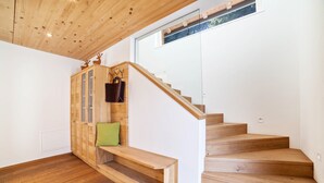 Un escalier en bois avec un banc et un meuble avec des portes en verre.