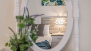 Ein Schlafzimmer mit Bett, Nachttisch, Lampe und einer Topfpflanze.