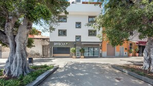 Un edificio con escaparate que dice 'BAMBOLA' y una puerta de garaje cerrada.