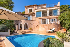 A two-story house with a swimming pool, outdoor furniture, and a garden. - Charming Villa “Villa Almeda” with Sea View, Pool, Wi-Fi, A/C, Terrace, & Garden (Puerto de Andratx)